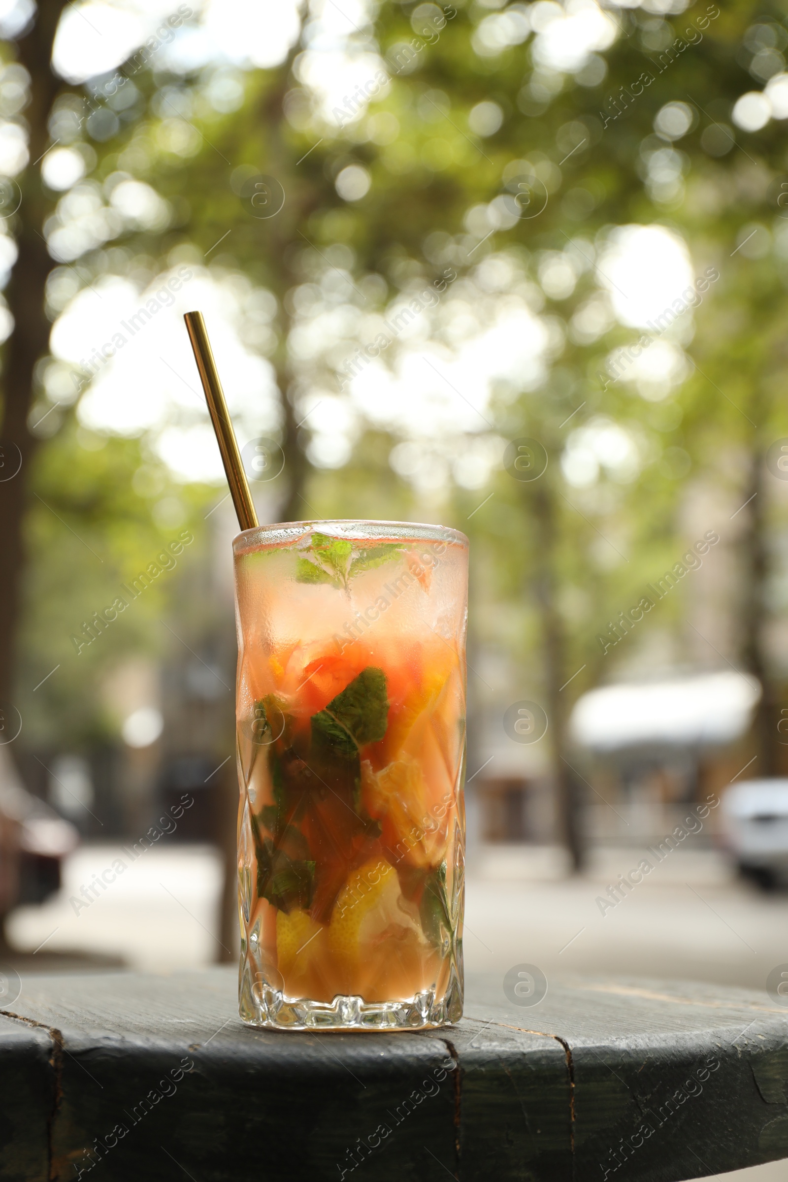 Photo of Glass of tasty refreshing drink and straw on table