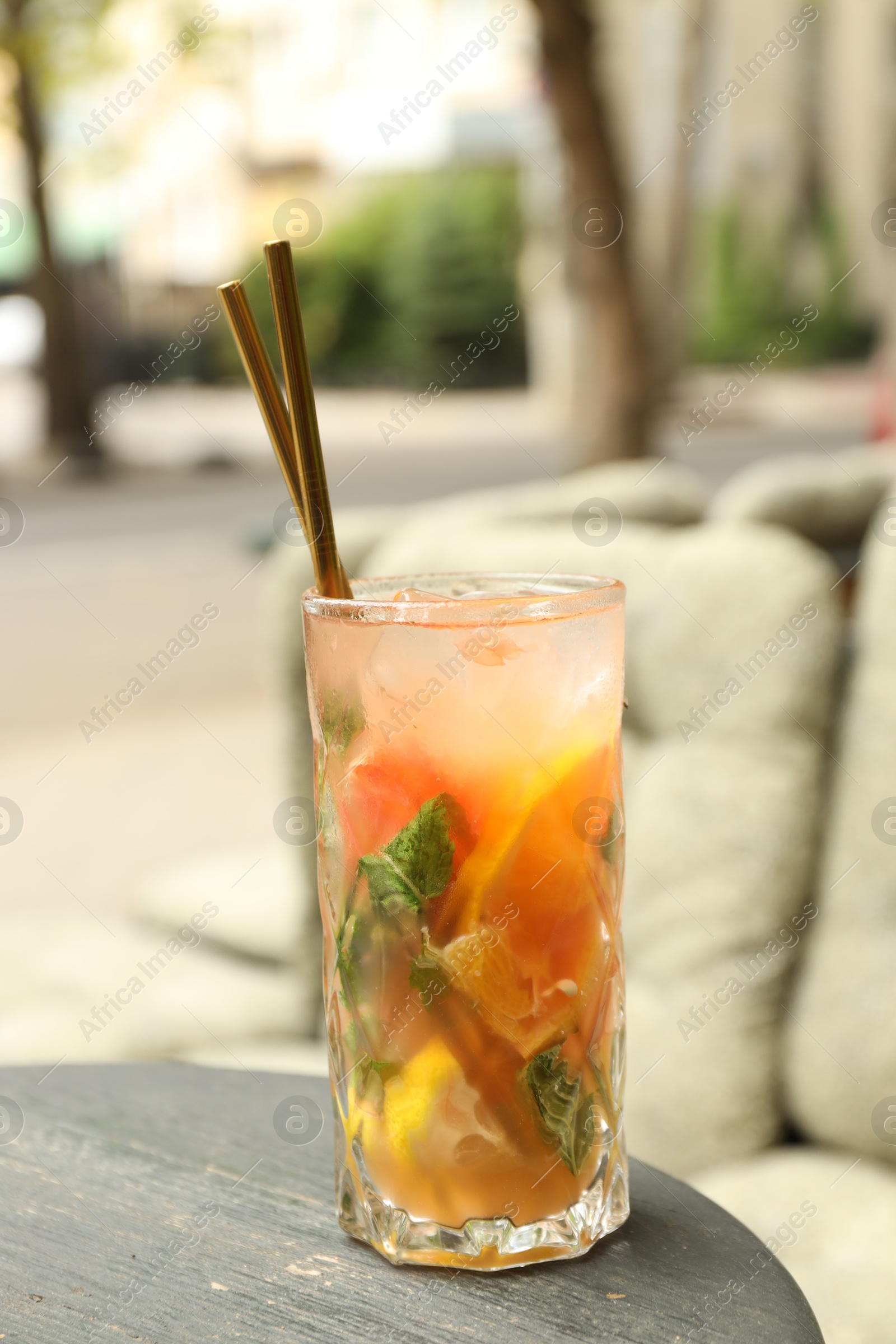 Photo of Glass of tasty refreshing drink and straws on table