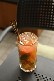 Photo of Glass of tasty refreshing drink and straws on table