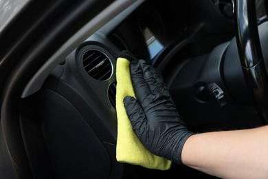 Man cleaning car interior with rag, closeup