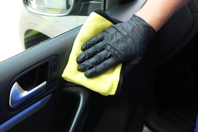 Photo of Man cleaning car interior with rag, closeup