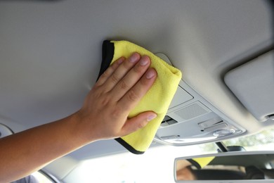 Photo of Man cleaning car interior with rag, closeup