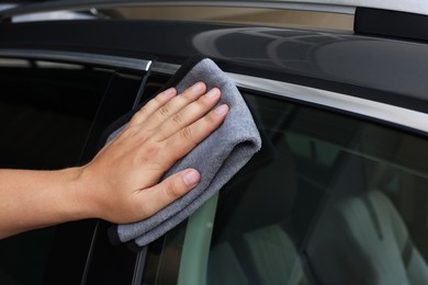 Man wiping car with grey rag, closeup