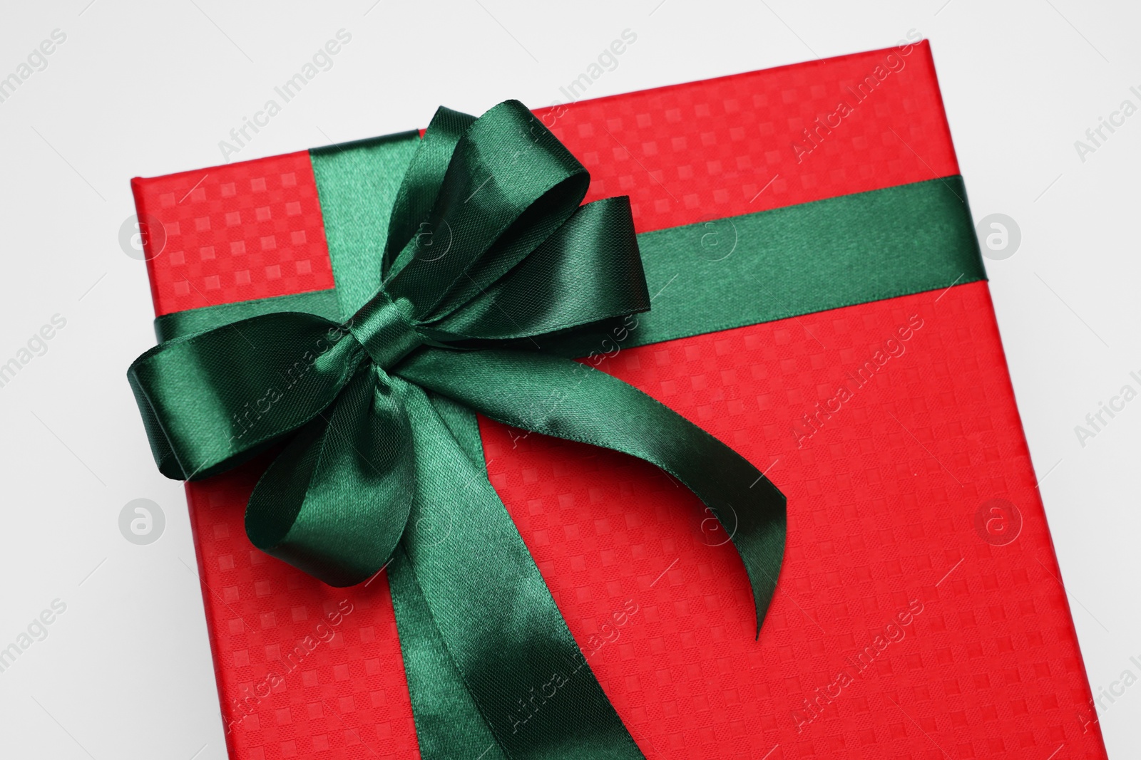 Photo of Gift box with green bow on light grey background, above view