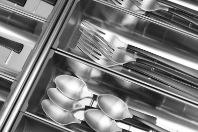 Photo of Box with cutlery in drawer, above view. Kitchen utensils storage