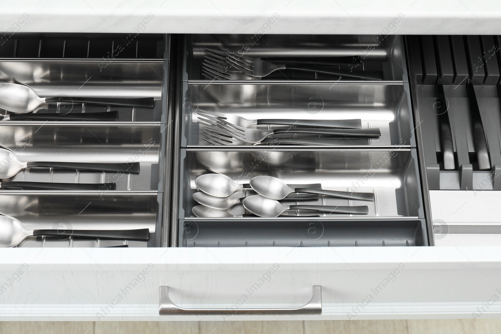 Photo of Box with cutlery in drawer, above view. Kitchen utensils storage