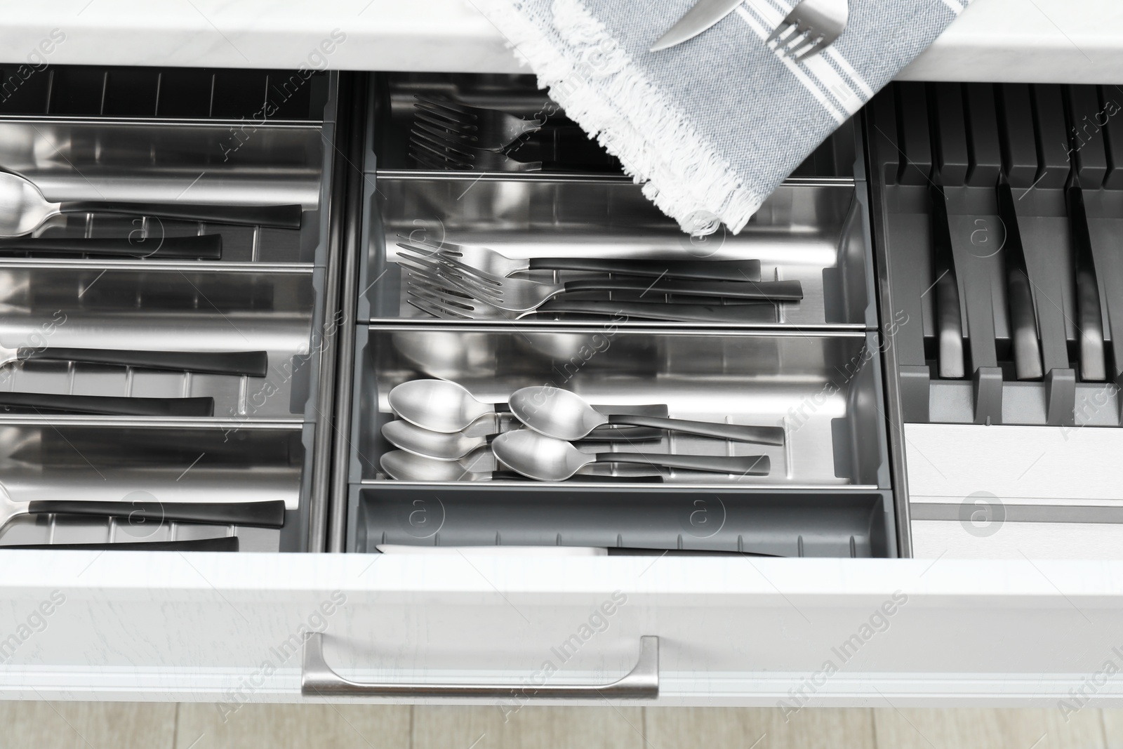 Photo of Box with cutlery in drawer, closeup. Kitchen utensils storage