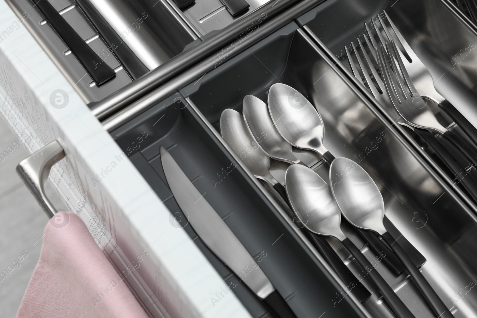 Photo of Box with cutlery in drawer, above view. Kitchen utensils storage