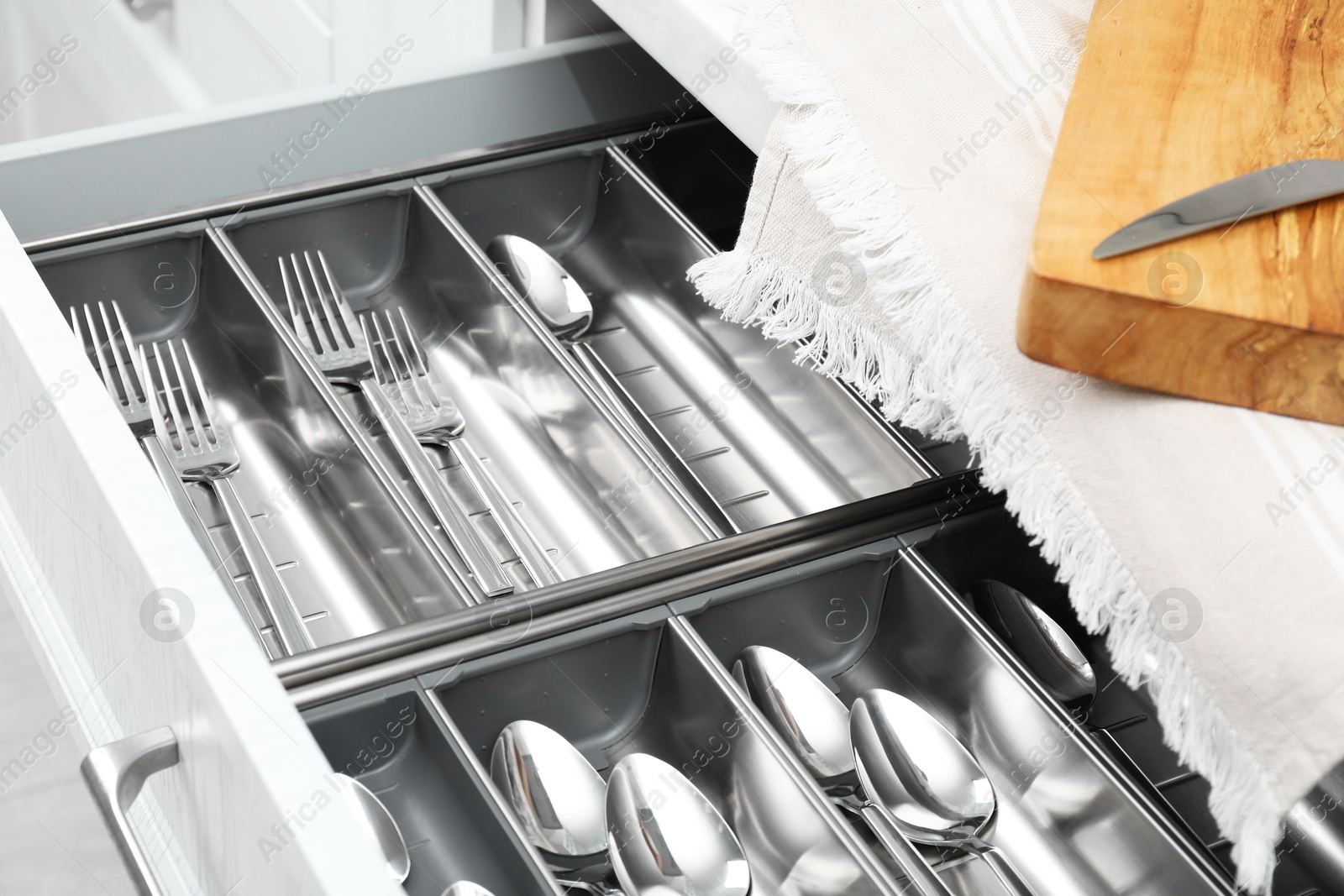 Photo of Box with cutlery in drawer, closeup. Kitchen utensils storage