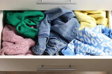 Photo of Cluttered chest of drawers indoors, closeup. Clothes in mess