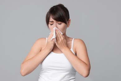 Photo of Woman with napkin suffering from sinusitis on grey background