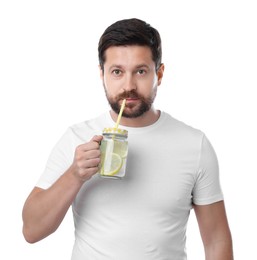 Photo of Handsome man drinking water with lemon on white background