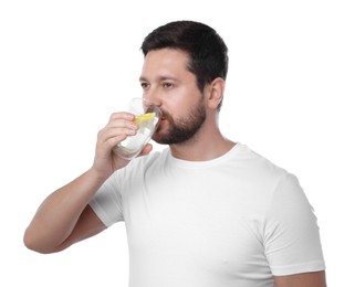 Photo of Handsome man drinking water with lemon on white background