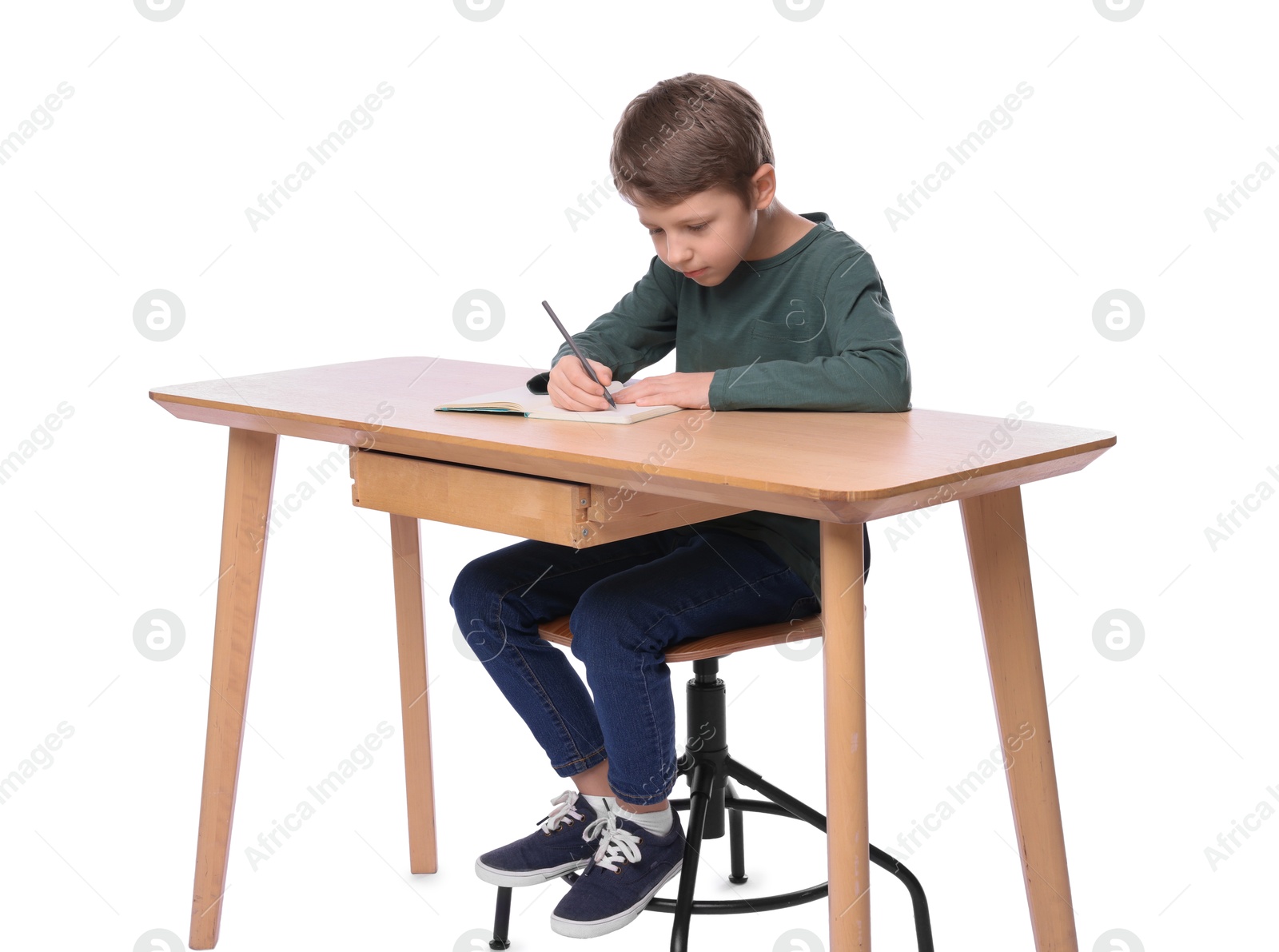 Photo of Boy with incorrect posture and notebook at wooden desk on white background