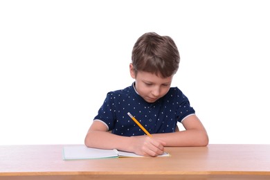 Photo of Boy with incorrect posture and notebook at wooden desk on white background