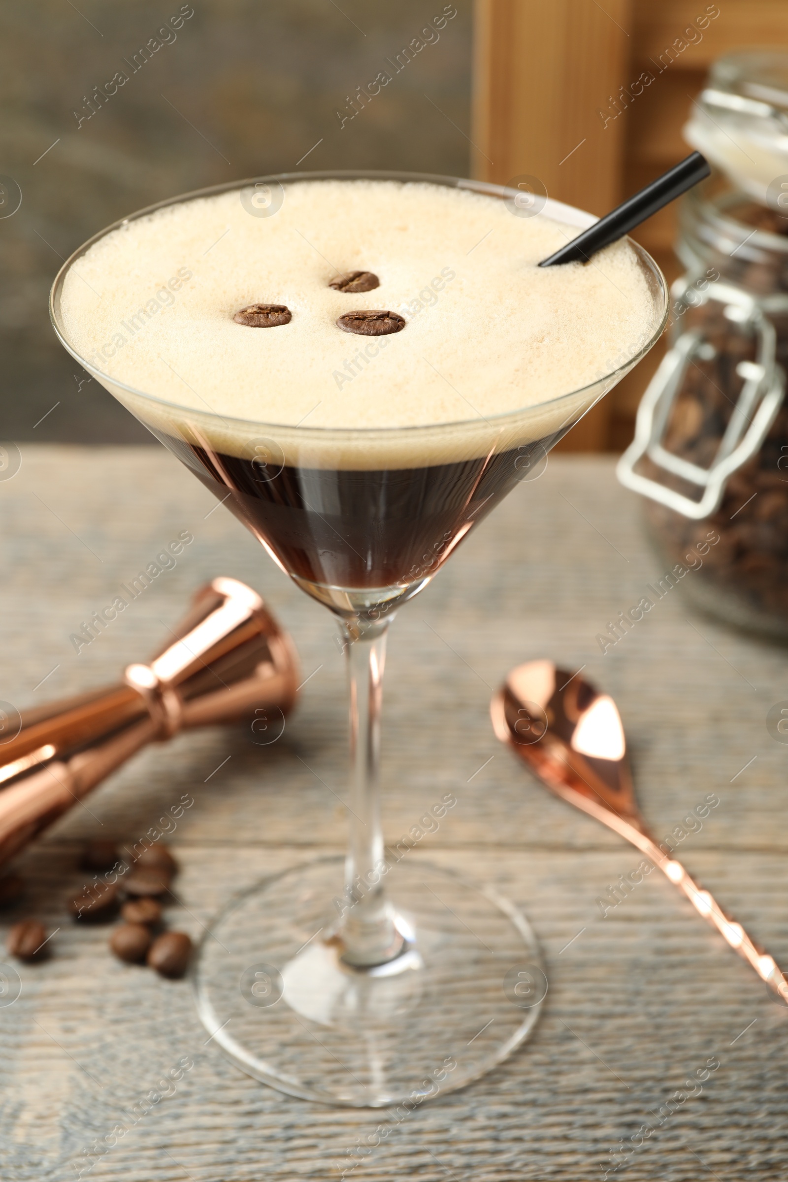 Photo of Delicious espresso martini with coffee beans in glass on wooden table