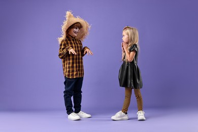 Photo of Cute children wearing costumes on violet background. Halloween celebration