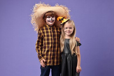 Photo of Cute children wearing costumes on violet background. Halloween celebration