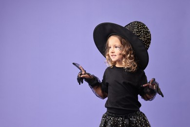 Funny girl dressed like witch for Halloween celebration on violet background, space for text