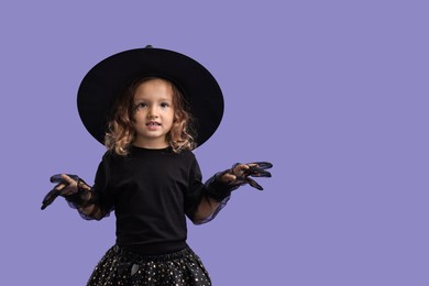 Funny girl dressed like witch for Halloween celebration on violet background, space for text