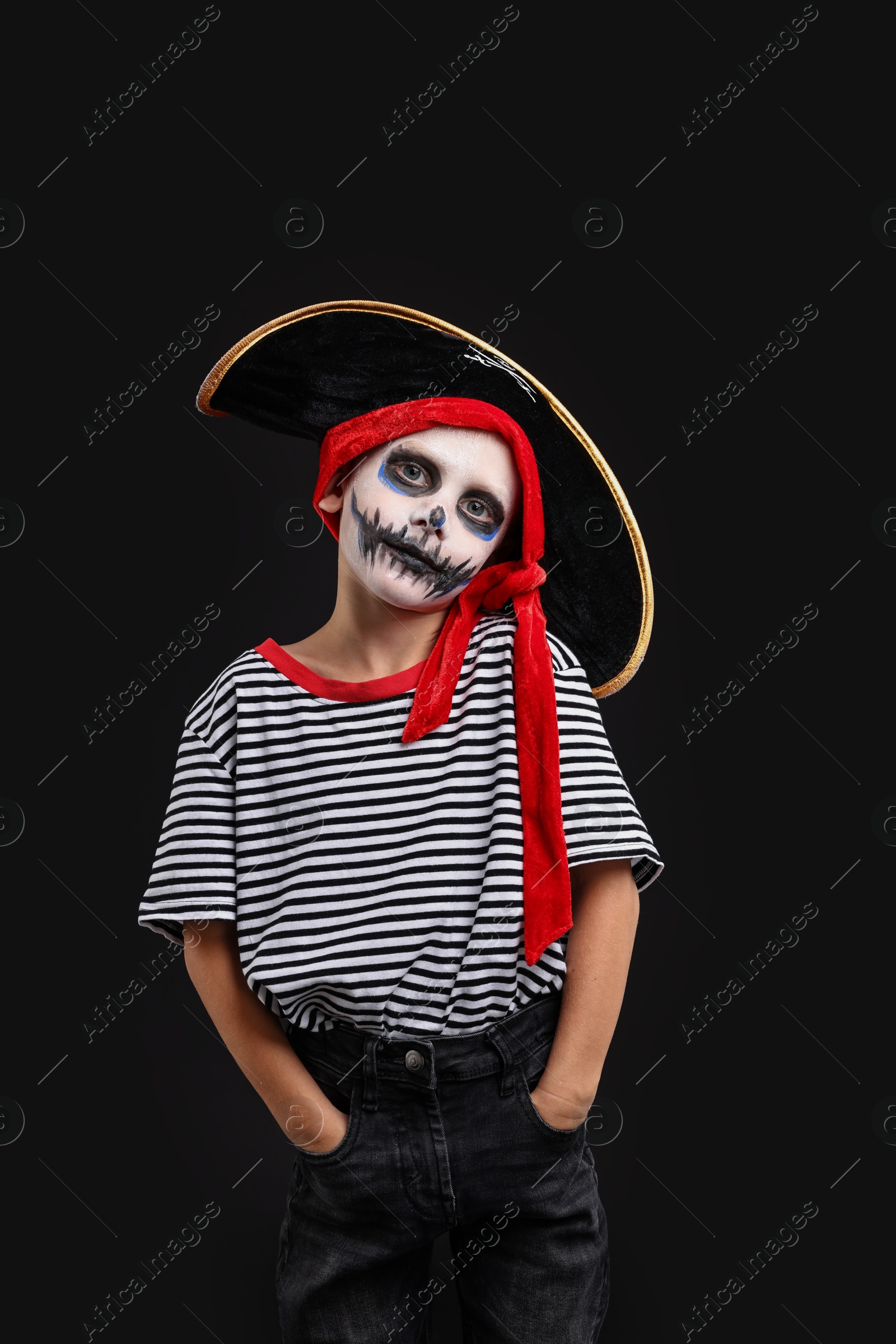 Photo of Funny boy dressed like pirate for Halloween celebration on black background