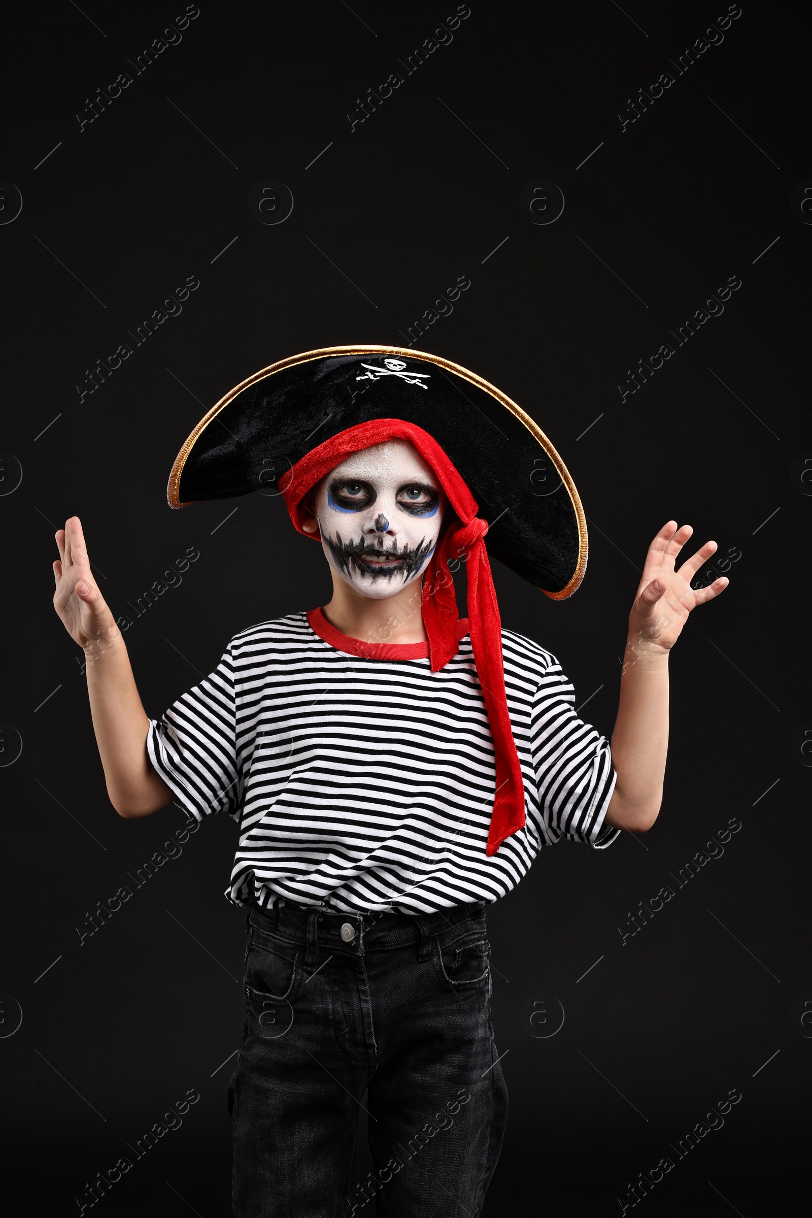 Photo of Funny boy dressed like pirate for Halloween celebration on black background