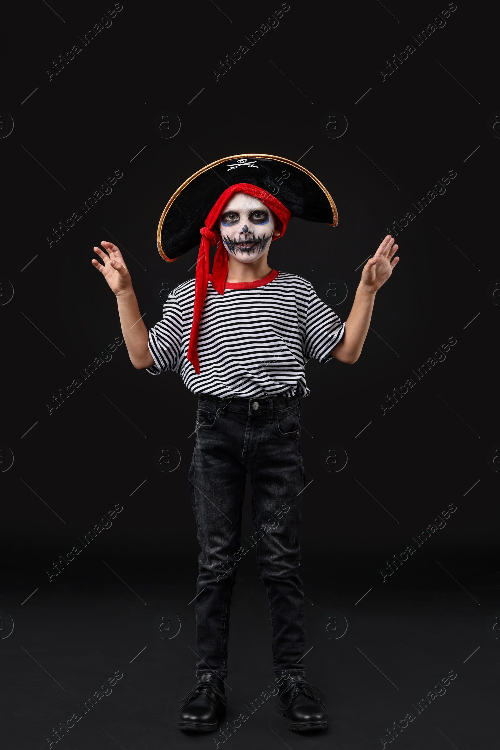 Photo of Funny boy dressed like pirate for Halloween celebration on black background