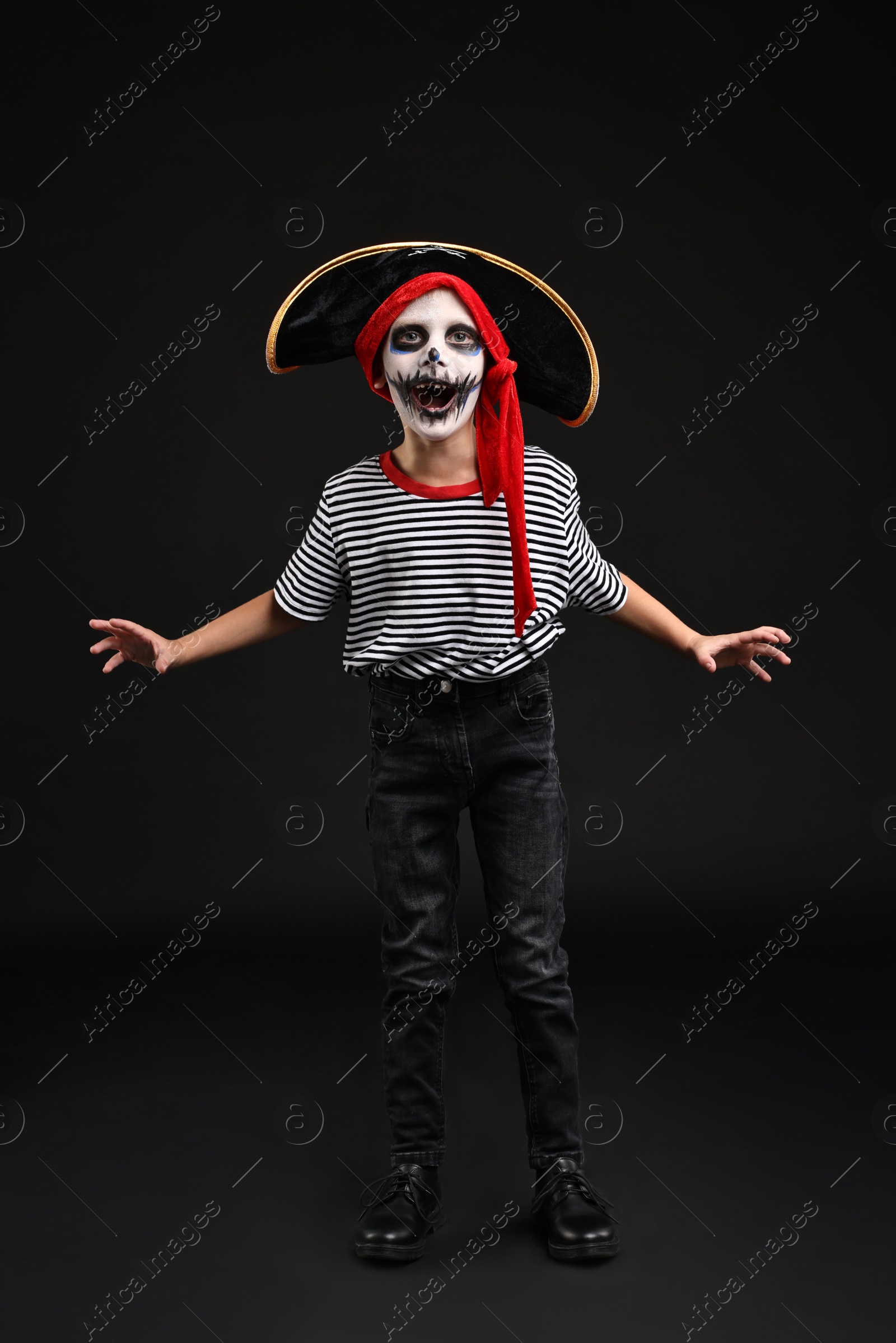 Photo of Funny boy dressed like pirate for Halloween celebration on black background