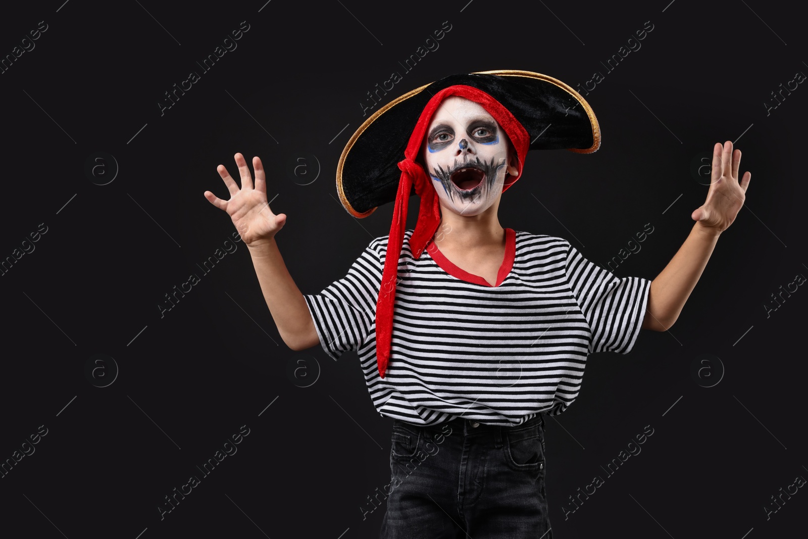 Photo of Funny boy dressed like pirate for Halloween celebration on black background