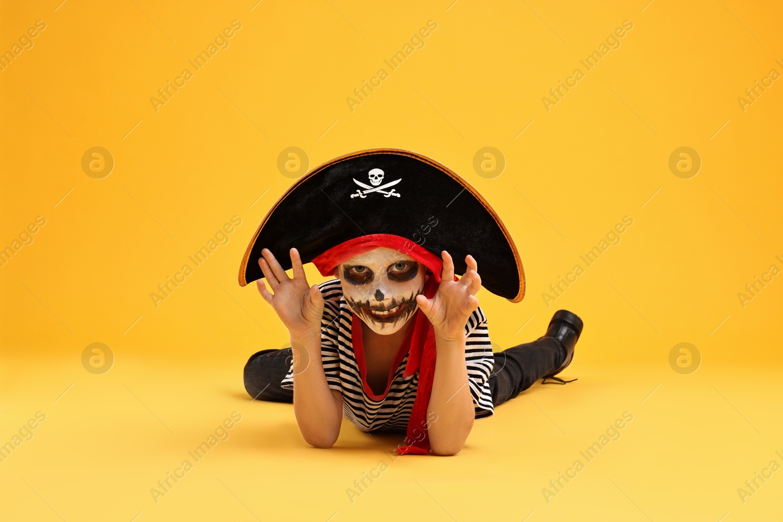 Photo of Funny boy dressed like pirate on yellow background. Halloween costume