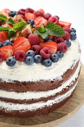 Photo of Delicious chocolate sponge cake with berries on light table, closeup