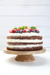 Photo of Delicious chocolate sponge cake with berries on light table