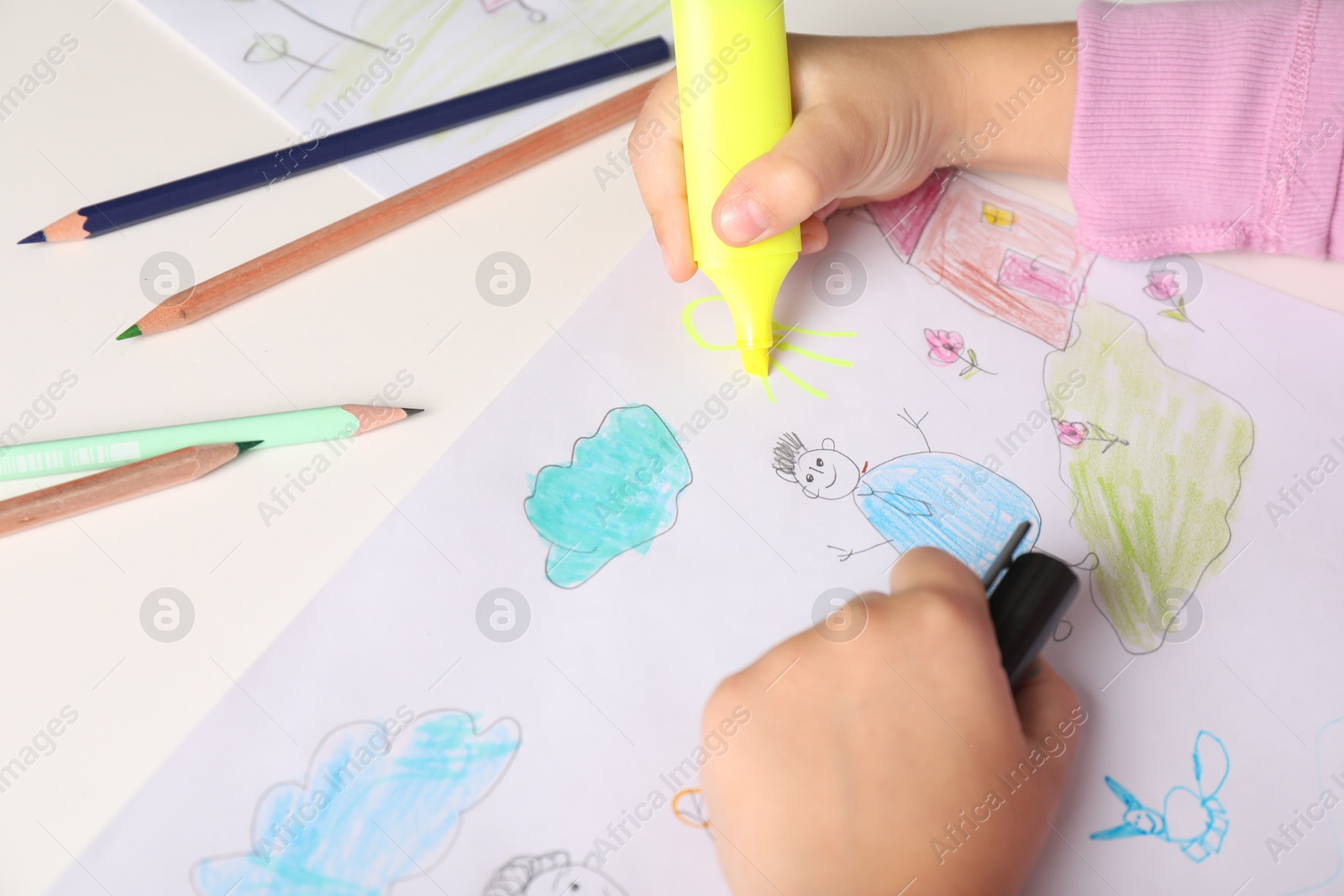 Photo of Little girl drawing his family at white table, closeup