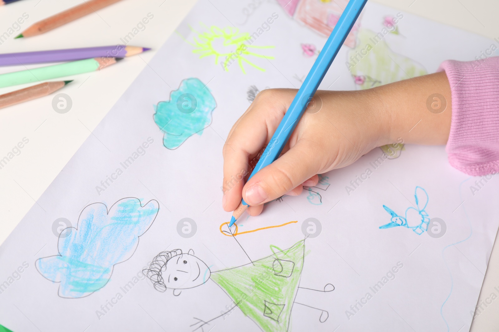 Photo of Little girl drawing his family at white table, closeup