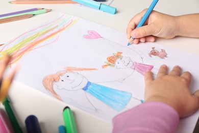 Little girl drawing his family at white table, closeup