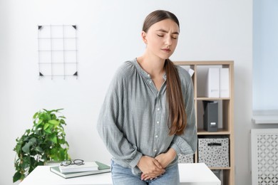 Woman suffering from menstrual pain in office