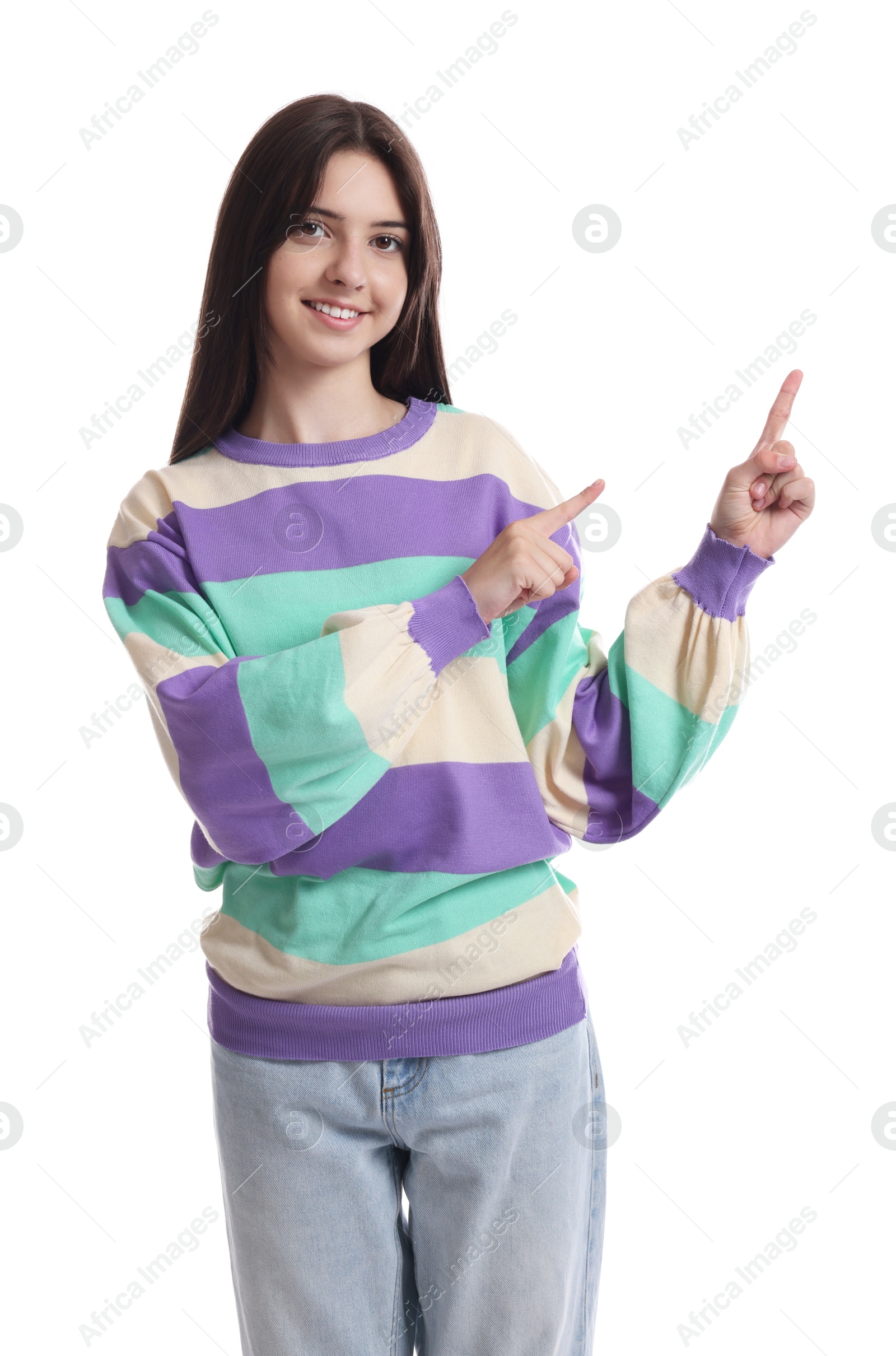 Photo of Portrait of cute teenage girl pointing at something on white background