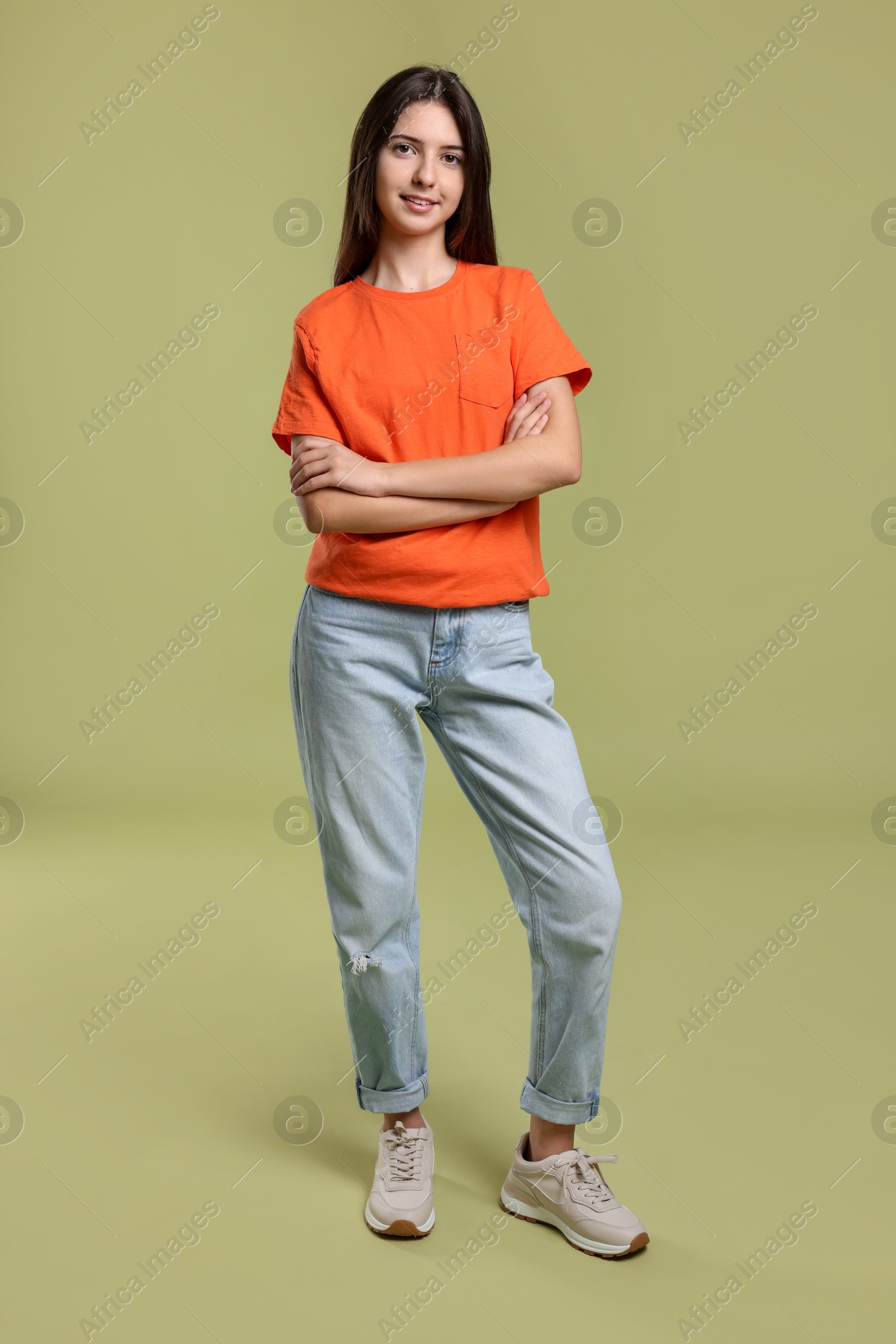 Photo of Full length portrait of cute teenage girl on olive background