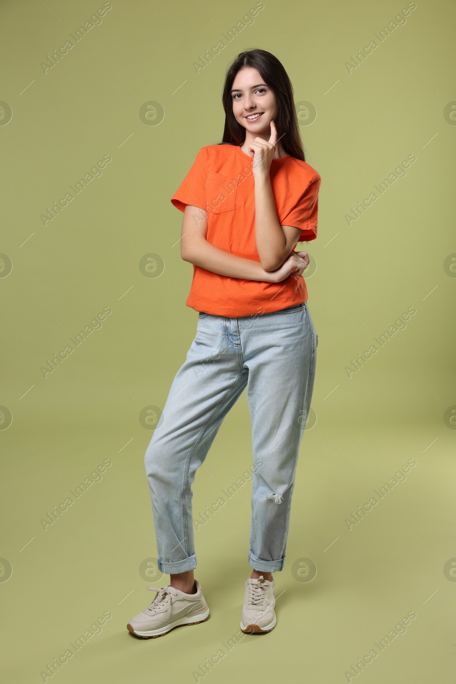 Photo of Full length portrait of cute teenage girl on olive background