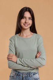 Portrait of cute teenage girl on beige background