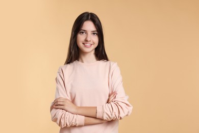 Portrait of cute teenage girl on beige background. Space for text