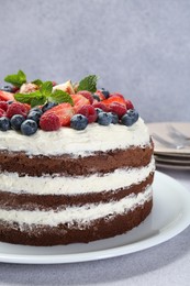 Photo of Delicious chocolate sponge cake with berries on light table, closeup