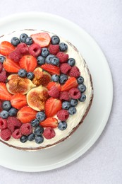 Delicious chocolate sponge cake with berries on light table, top view