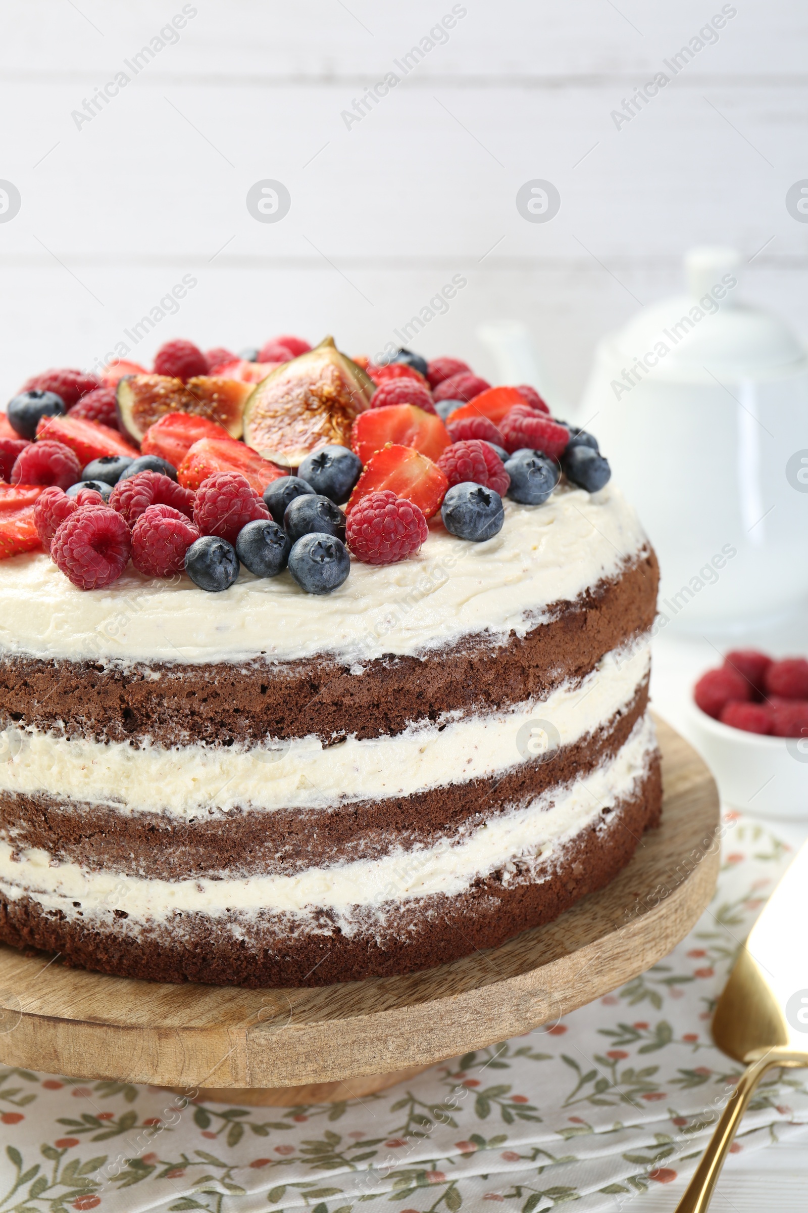 Photo of Delicious chocolate sponge cake with berries on table, closeup