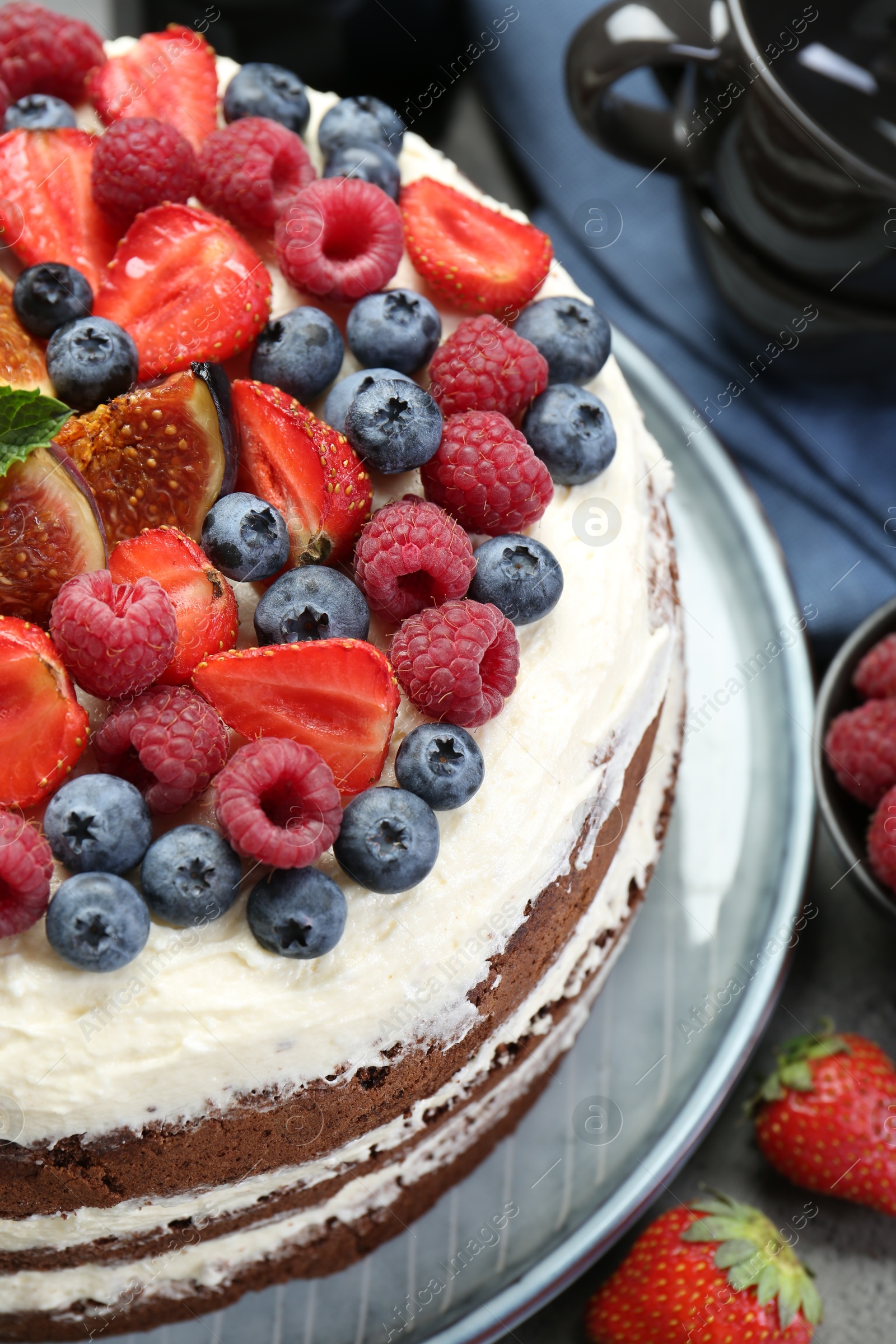 Photo of Delicious chocolate sponge cake with berries on table, closeup