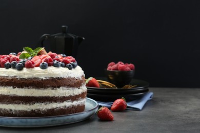 Photo of Delicious chocolate sponge cake with berries served on grey table. Space for text