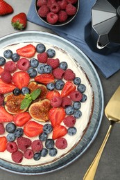 Photo of Delicious chocolate sponge cake with berries served on grey table, top view