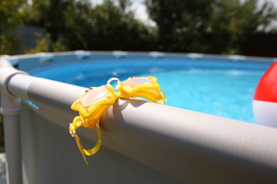 Swimming goggles for kids on top rail of pool, closeup