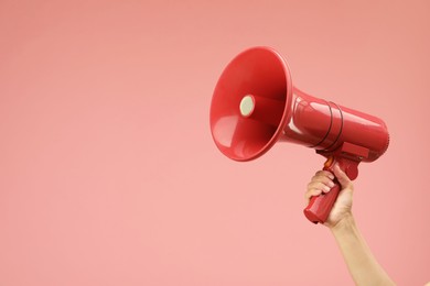 Photo of Woman holding megaphone speaker on pink background, closeup. Space for text