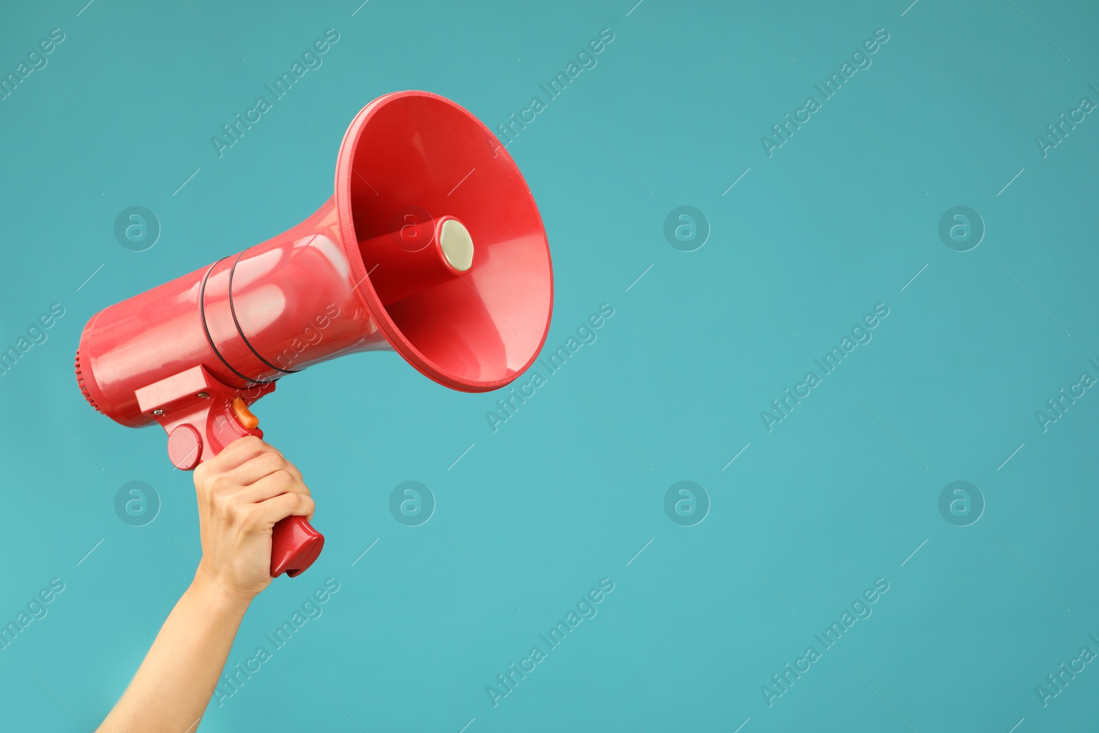 Photo of Woman holding megaphone speaker on blue background, closeup. Space for text